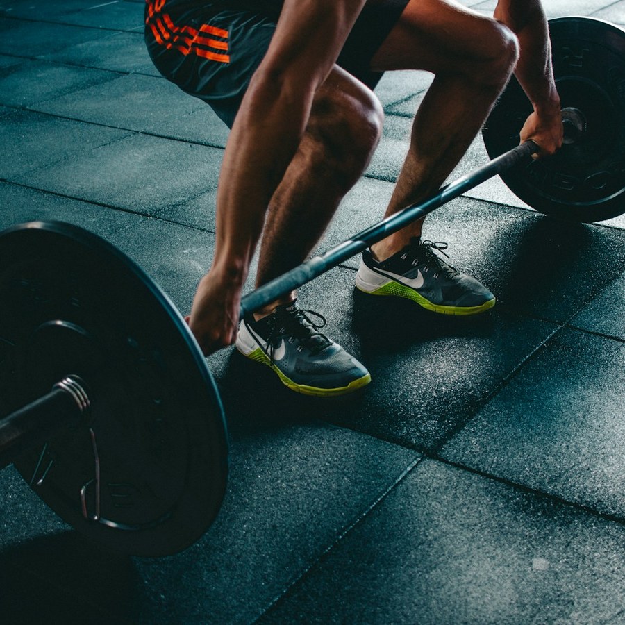 Athlete lifting a barbell mid-set in a gym