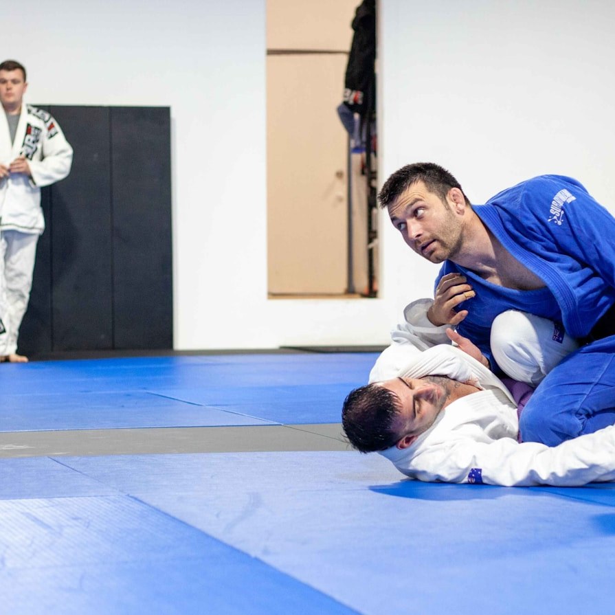 People practicing grappling on martial arts mats